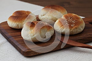 baked white bread on wood cutting board isolated on table