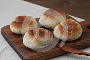 baked white bread on wood cutting board isolated on table