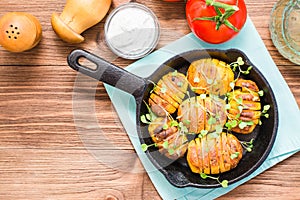 Baked young potatoes in spices and oil with arugula in a pan