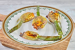 Baked zucchini or courgette flowers with parmesan cheese in casserole dish, italian appetizer