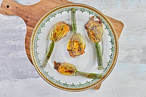 Baked zucchini or courgette flowers with parmesan cheese in casserole dish, italian appetizer