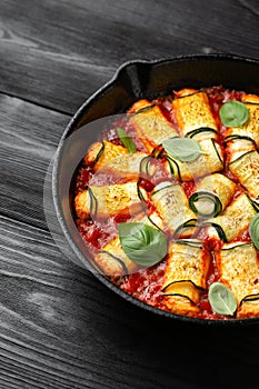 Baked zucchini rolls with ricotta, pecorino cheese in marinara sauce. Healthy food