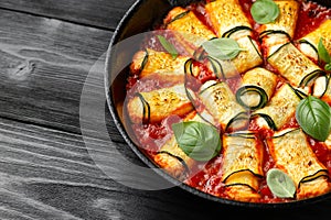 Baked zucchini rolls with ricotta, pecorino cheese in marinara sauce. Healthy food