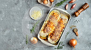 Baked zucchini, stuffed with meat on the gray background