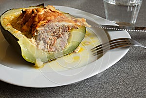 Baked zucchini, stuffed with meat on a white plate