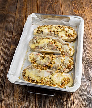 Baked zuchinni on a roasting pan on a wooden table.