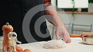 Baker adding flour on the pile by hand