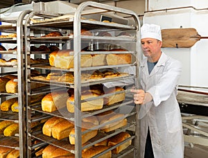 Baker carrying fresh bread on trolley