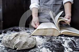 Baker chef looking for a recipe in a cookbook