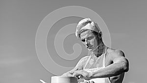 Baker concept. Man on busy face wears cooking hat and apron, sky on background. Cook or chef with muscular