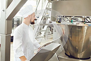 A baker controls the process of creating dough for baking bread.