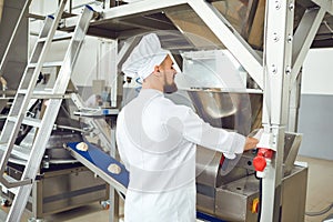 A baker controls the process of creating dough for baking bread.