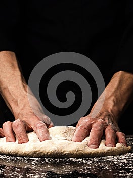 Baker or cook kneads an organic yeast dough, traditional handwork