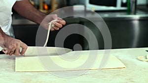 Baker cutting dough for croissants