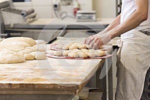 Baker with dough for buns