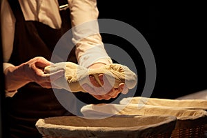 Baker with dough rising in baskets at bakery