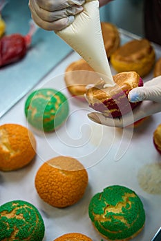 Baker filling up choux au craquelin with condensed milk photo