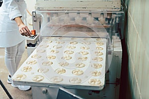 Baker forming bread rolls with a machine