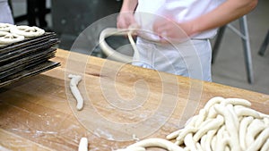 Baker forming pretzel from dough in bakery