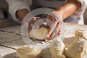 Baker hands preparing bread loaves kneading dough