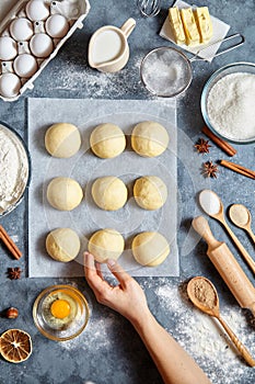 Baker hands preparing dough for buns ingridients food flat lay on kitchen table