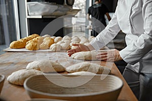 Baker hands preparing formed bread dough for proofing