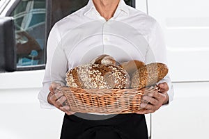 Baker Holding A Basket Of Bread Loaf