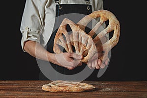 Baker is holding fougas bread