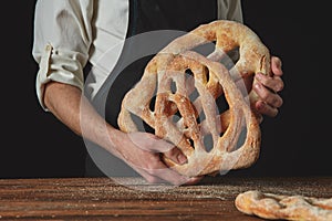 Baker is holding fougas bread