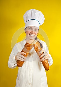 Baker holding long bread rolls