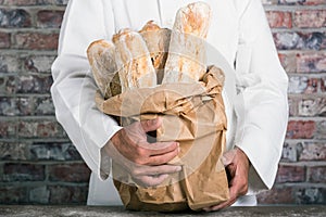 Baker holding traditional bread french baguettes