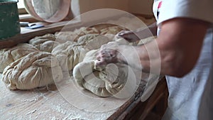 Baker kneading dough for bread on table