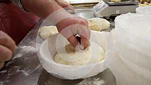 baker kneading dough for making bread