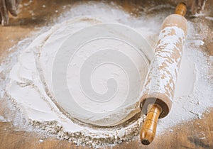 Baker pours flour for making pizza. Chef cooking dough to bake a cake on a wooden table.