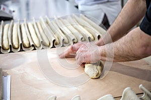 The baker makes the dough for crispy French baguettes photo