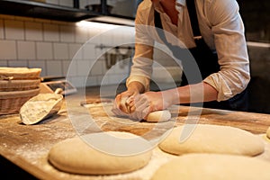 Baker making bread dough at bakery kitchen