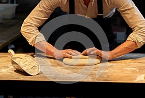 Baker making bread dough at bakery kitchen