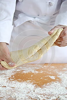 Baker making bread, kneading a dough