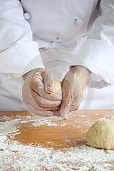 Baker making bread, kneading a dough