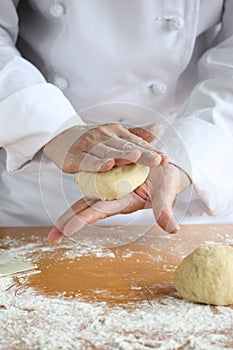 Baker making bread, kneading a dough