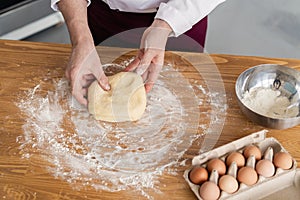Baker making bread , man hands , kneading a dough , cooking coat.