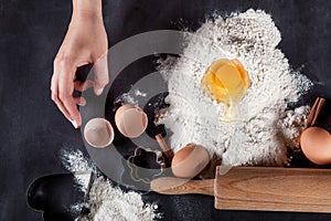 Baker is making cookies with wooden rolling pin