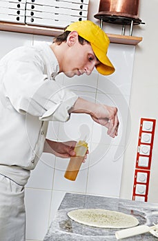 Baker making dough for Pizza