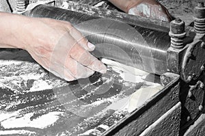 Baker making dough on sheeter