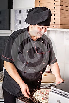 Baker making pizza at the pizzeria kitchen