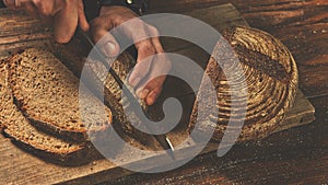 Baker man slices bread