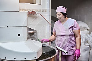 Baker mix dough with professional kneader machine at the manufacturing. Equipment for making flour products