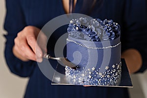 The baker is out of focus. Portrait of caucasian woman sharing fresh cake.