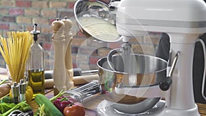 Baker pouring flour powder in mixer for kneading dough in bakery.Cook pouring flour in kitchen machine for mixing dough