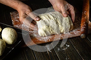 The baker prepares the dough for baking buns. The concept of baking confectionery for hot dogs in the bakery